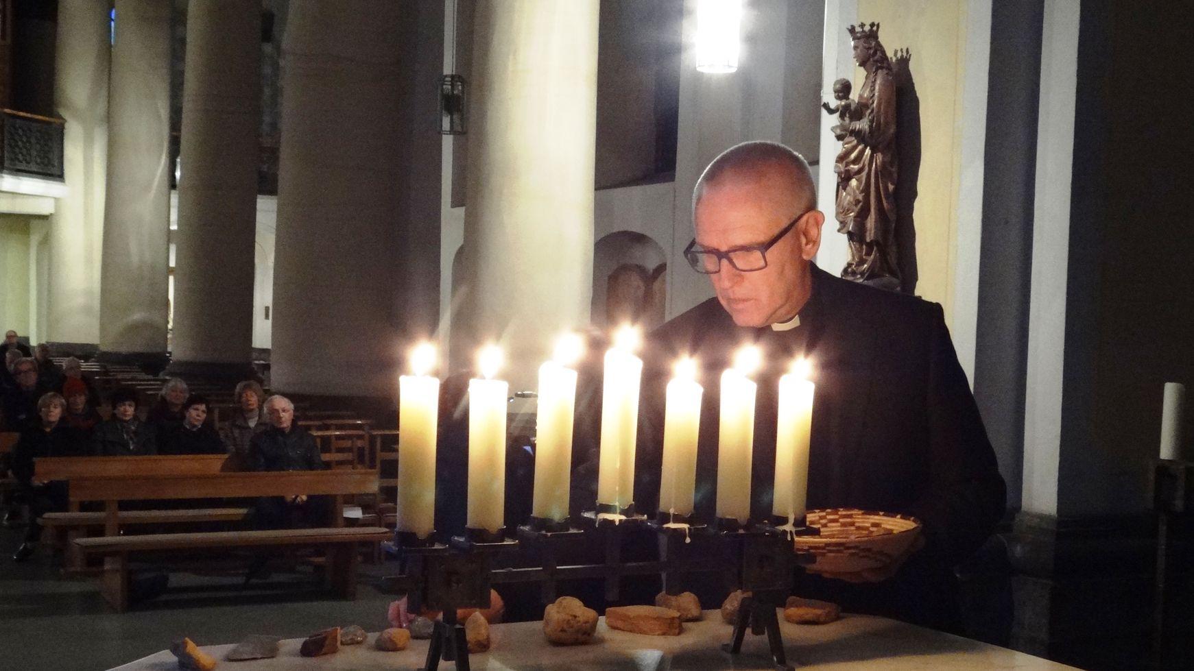 Pfarrer Rainer Gattys legt in Erinnerung an die Würselener Juden Steine auf den Altar.