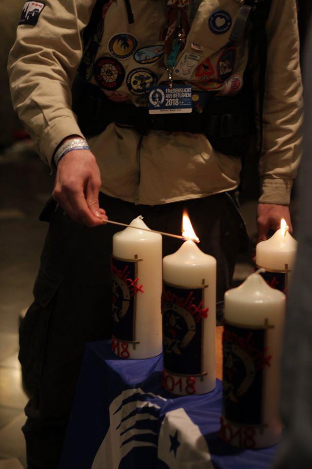 Ein Pfadfinder verteilt die Flamme aus Betlehem